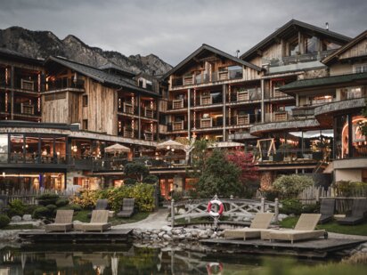 Hotel der Engel mit Bergsee im Vordergrund bei Abendstimmung von Außen