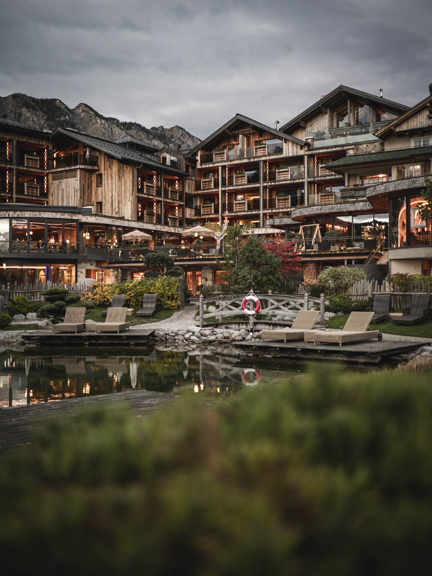 Hotel der Engel mit Bergsee im Vordergrund bei Abendstimmung von Außen