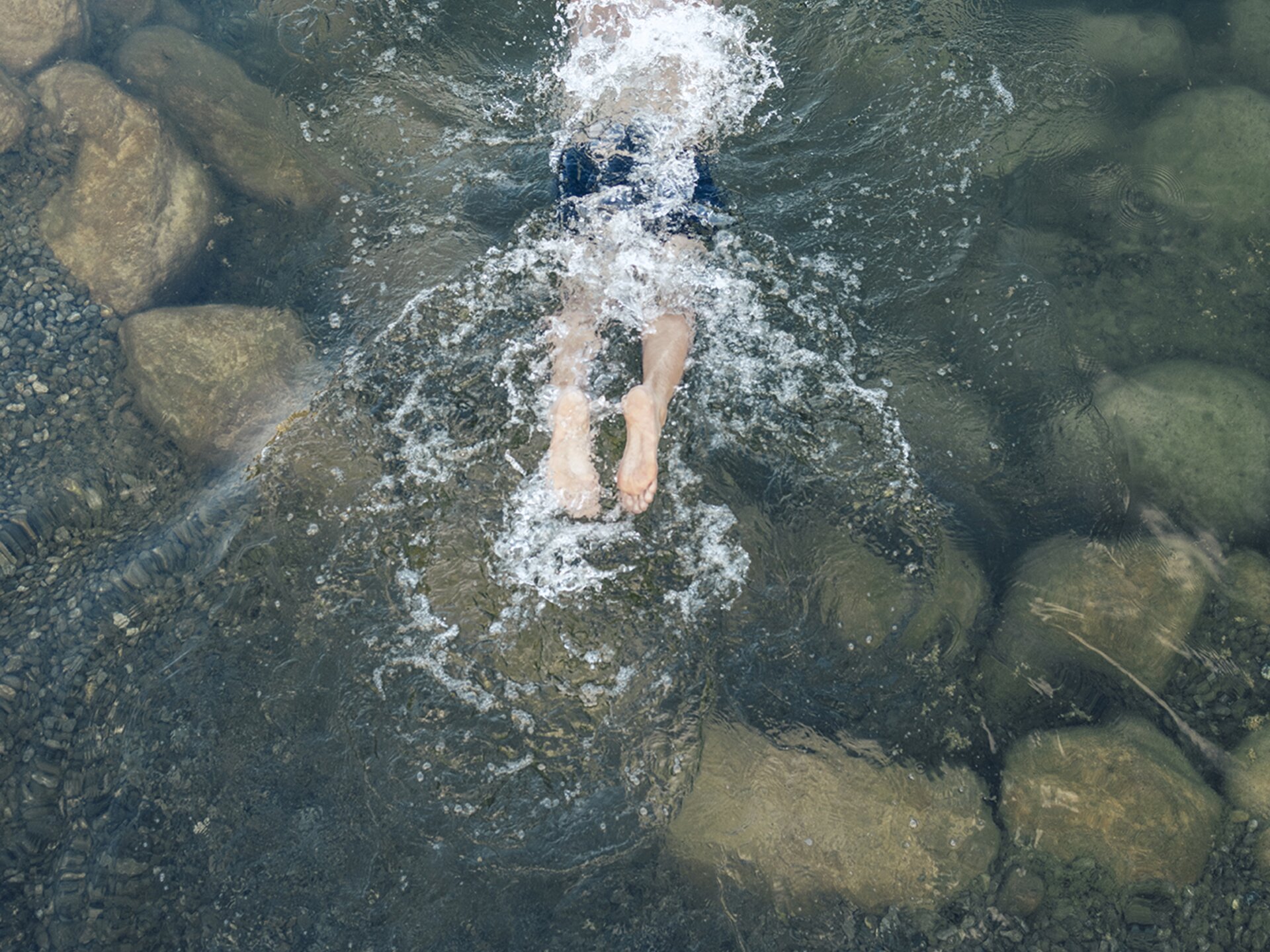 Person taucht in den Engel Bergsee ein