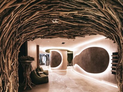 Eingangsbereich aus Treibholz im Orgänic Spa mit Fischen als Lichtspiel auf dem Boden