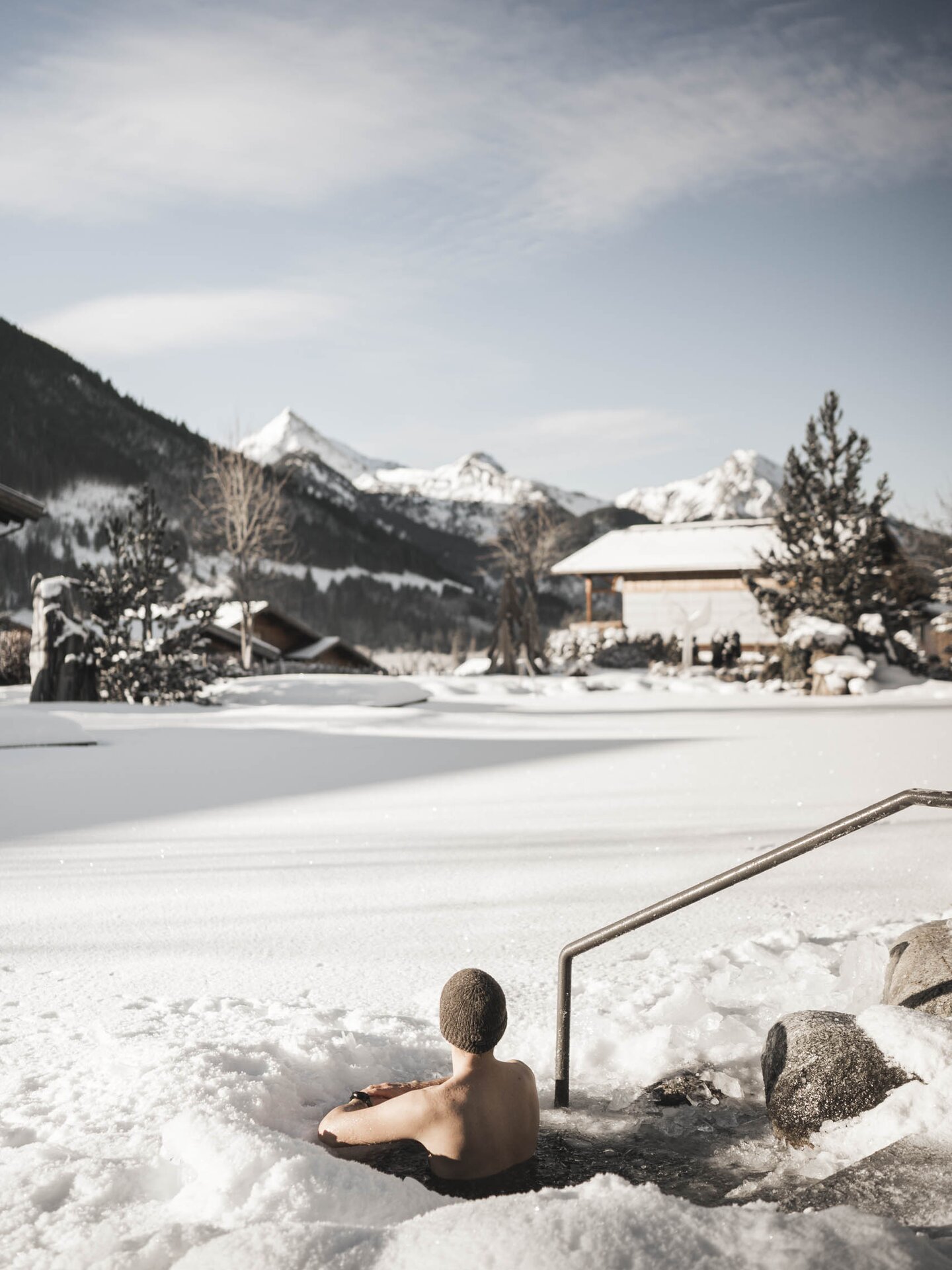 Person beim Eisbaden im Engel Bergsee mit schneebedeckter und vereister Oberfläche