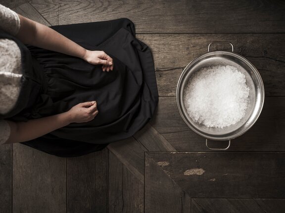 Person knieend vor Schüssel mit Eis - auf Holzboden im Dirndle - Orgänic Treats Keyvisual