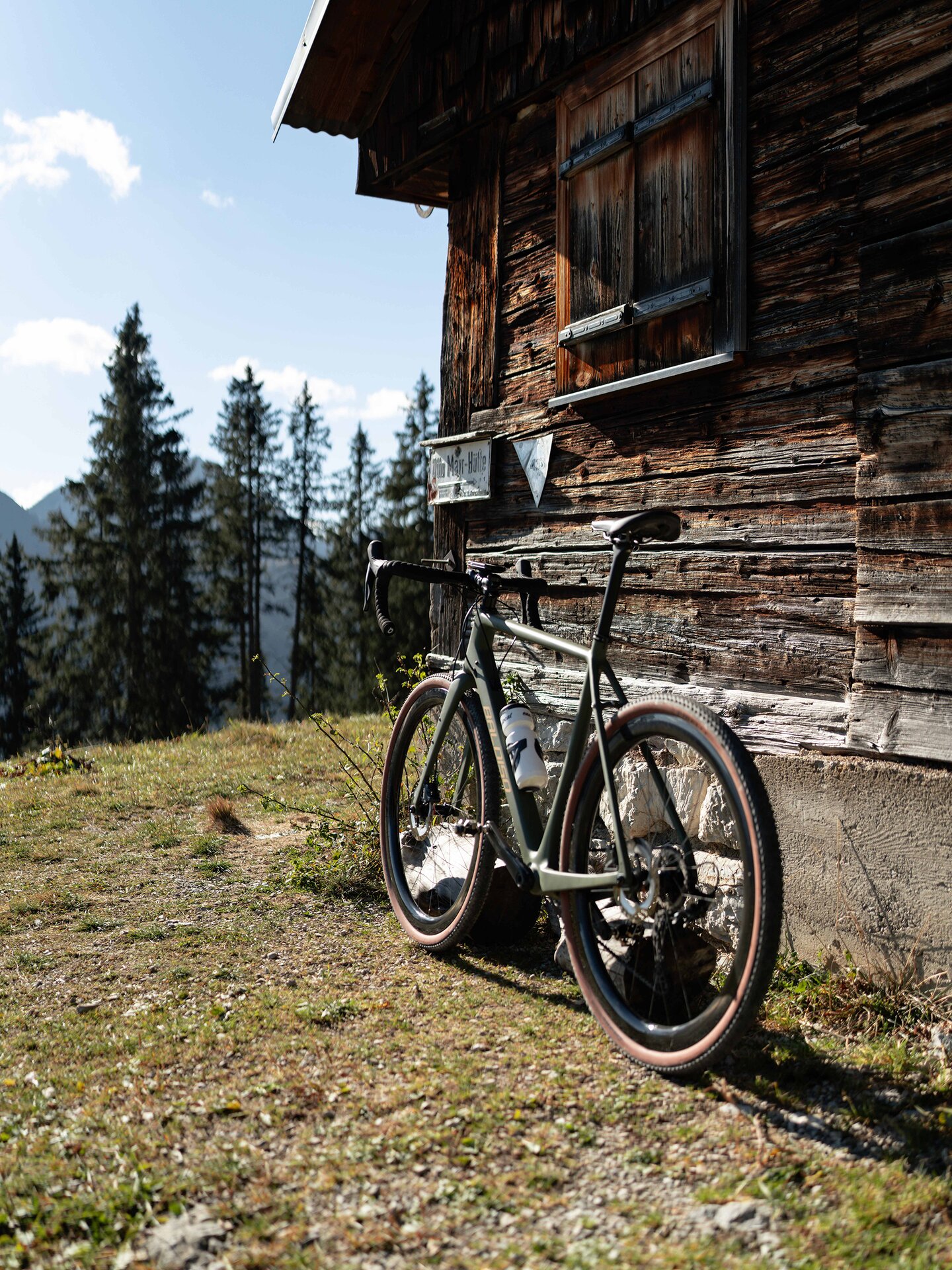Gravelbike vor alter Holzhütte am Berg im Tannheimer Tal