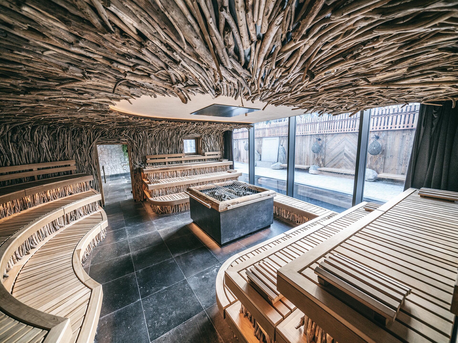 Sauna im Orgänic Spa mit geschwungenen Holzbänken und Naturholzdecke