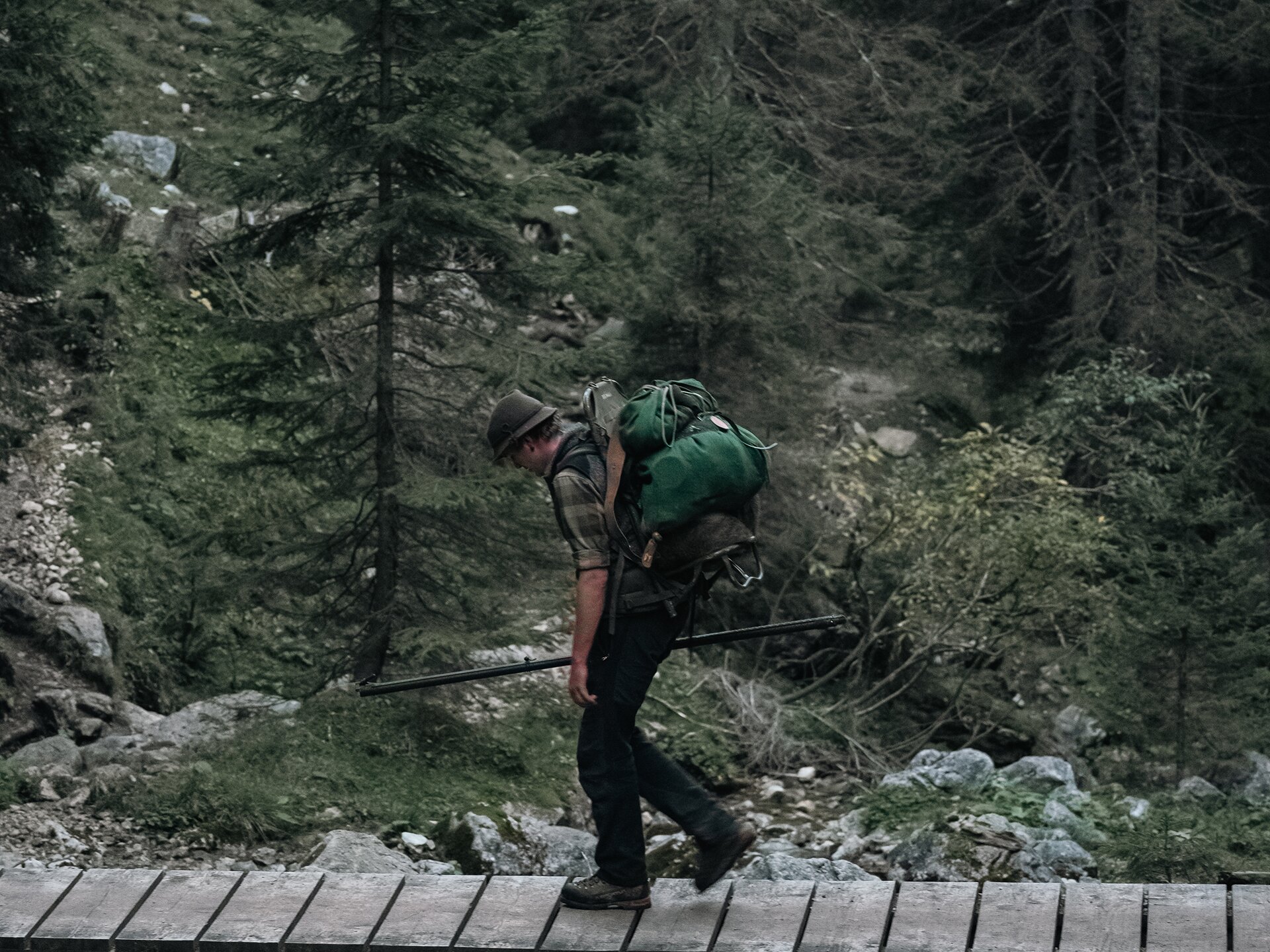 Jäger beobachtet mit einem Fernglas die herbstliche Berglandschaft im Tannheimer Tal