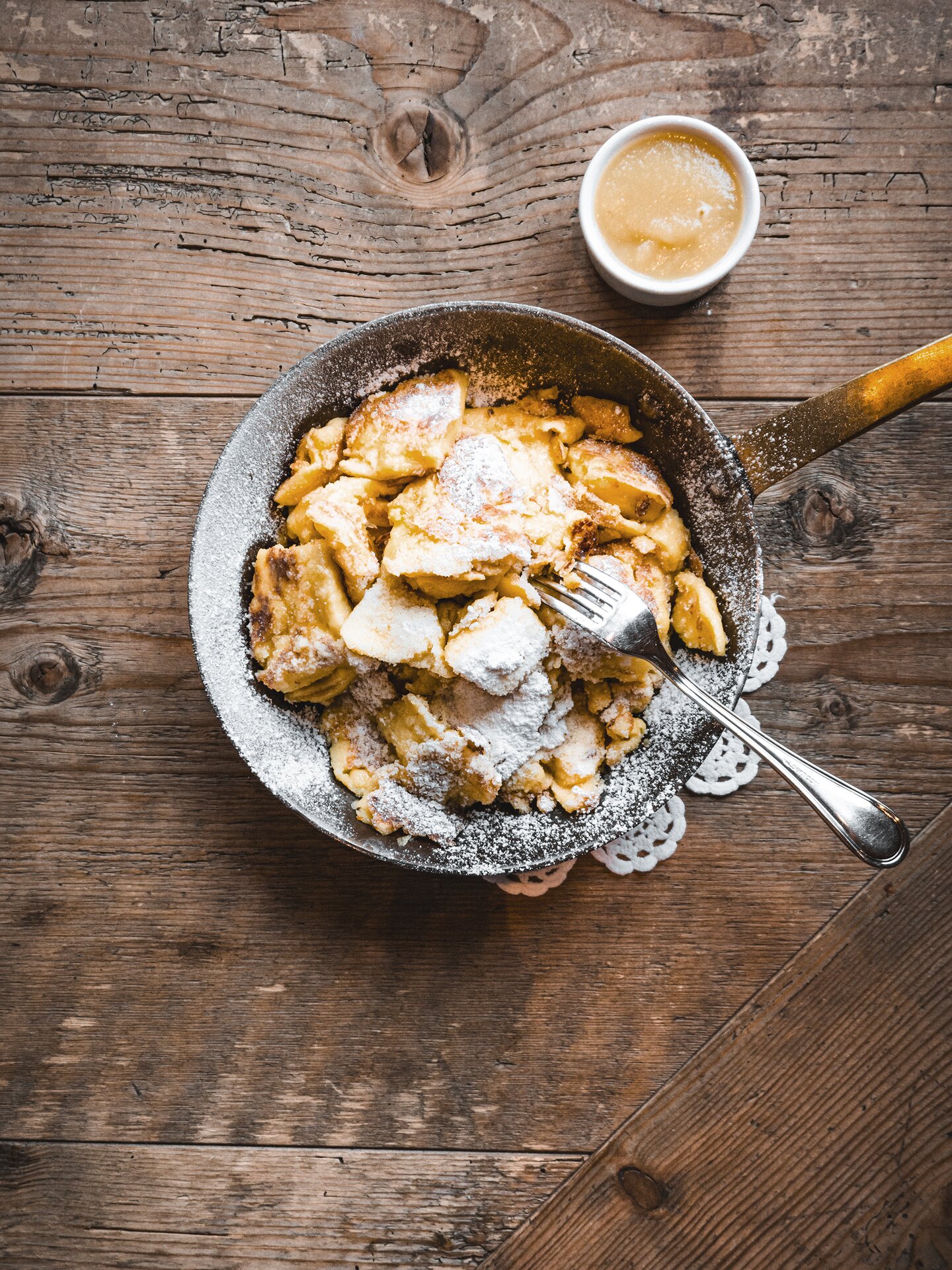 Kaiserschmarren in einer Eisenpfanne auf einem traditionellen Holztisch | Der Engel Kaiserschmarren in einer Eisenpfanne auf einem traditionellen Holztisch | Der Engel